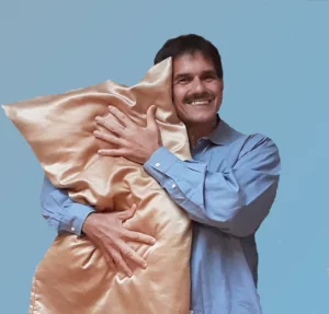 Handsome guy with mustache hugging pillow